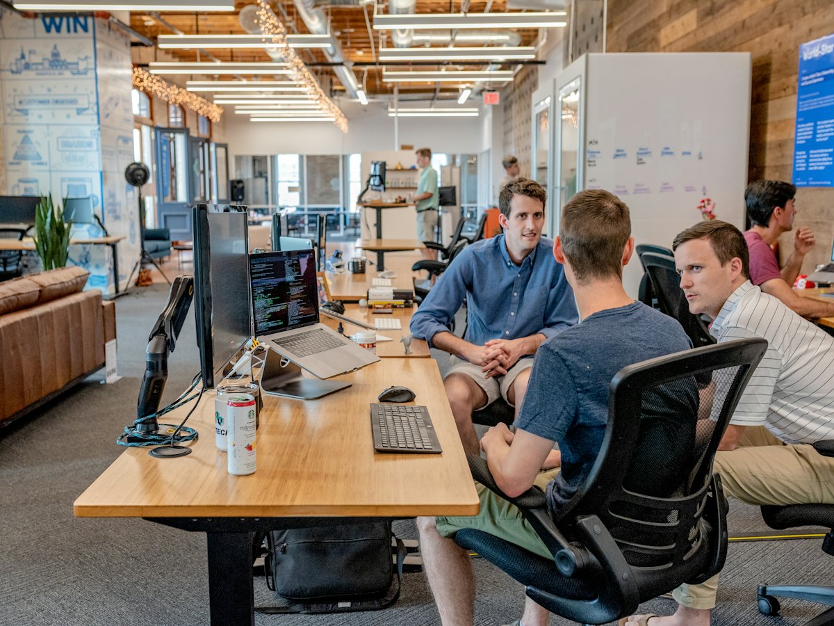 Engineers discussing work at their desks